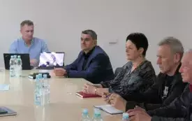 Uczestnicy spotkania siedzą przy stole na sali konferencyjnej w Urzędzie Miejskim w Łochowie